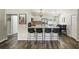 Kitchen with counter seating, white cabinets, stainless appliances, and wooden floors at 40143 Babb Rd, Umatilla, FL 32784