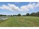 Beautiful lakefront property with green grass, a boat, and mature trees at 40143 Babb Rd, Umatilla, FL 32784