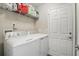 Laundry room featuring appliances, white door and shelving for organized storage at 40143 Babb Rd, Umatilla, FL 32784
