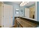 Spacious bathroom features a long granite countertop, a large mirror, and neutral paint at 4083 Capland Ave, Clermont, FL 34711