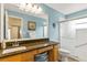 The bathroom has a large mirror, vanity with granite countertops, and a glass-enclosed shower at 4083 Capland Ave, Clermont, FL 34711