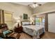 Comfortable bedroom features a ceiling fan, a recliner, and sliding glass door to the lanai at 4083 Capland Ave, Clermont, FL 34711