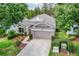 An angled view of a single-story home featuring a brick paver driveway and lush landscaping at 4083 Capland Ave, Clermont, FL 34711