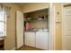 Bright laundry closet features wood-look flooring and white washer/dryer at 4083 Capland Ave, Clermont, FL 34711