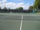 Well-maintained tennis court with a net and dark privacy screening in a residential community at 4083 Capland Ave, Clermont, FL 34711
