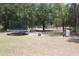 Spacious backyard featuring a trampoline and fire pit amongst mature trees at 41 Dogwood Loop, Ocala, FL 34472