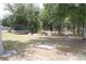 Large backyard featuring a trampoline, firepit, and gardening bed amongst mature trees at 41 Dogwood Loop, Ocala, FL 34472