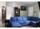 Spacious living room with plush blue sectional, wood-look flooring, and neutral wall color at 41 Dogwood Loop, Ocala, FL 34472