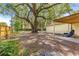 Expansive backyard featuring mature trees and partially covered patio, enhancing outdoor living at 43 Almond Pass Dr, Ocala, FL 34472