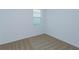 A carpeted bedroom with white walls, base trim, and window at 532 Silver Palm Dr, Haines City, FL 33844