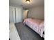 Well-lit bedroom with a comfortable bed and a view of the room featuring neutral walls and plush carpet at 5547 Se 91St Pl, Ocala, FL 34480