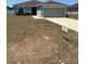 Inviting single-story home featuring a well-manicured lawn and a two-car garage, creating a welcoming curb appeal at 5547 Se 91St Pl, Ocala, FL 34480