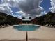 A full view of the community pool surrounded by lounge chairs, palm trees, and manicured grounds at 5560 Metrowest Blvd # 3-204, Orlando, FL 32811
