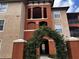 Multi-story condo building with red brick and light beige exterior and green decorative plant archway at 5560 Metrowest Blvd # 3-204, Orlando, FL 32811