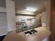 Kitchen area with stainless sink, white cabinetry, and white appliances at 5560 Metrowest Blvd # 3-204, Orlando, FL 32811