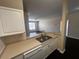 Open kitchen view of a stainless steel sink, dishwasher, and bright living area with dark hardwood floors at 5560 Metrowest Blvd # 3-204, Orlando, FL 32811