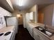 Bright kitchen features white cabinets, countertops, stainless steel sink, and includes access to the laundry room at 5560 Metrowest Blvd # 3-204, Orlando, FL 32811