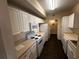 Kitchen featuring white appliances and cabinets with wood-look flooring at 5560 Metrowest Blvd # 3-204, Orlando, FL 32811