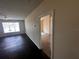 Bright living room with hardwood floors features a ceiling fan, large window, and view to carpeted room at 5560 Metrowest Blvd # 3-204, Orlando, FL 32811