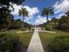 Beautiful view of the pool surrounded by lush landscaping, palm trees, and community buildings at 5560 Metrowest Blvd # 3-204, Orlando, FL 32811