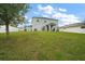 Large, grassy backyard showcasing a two-story home with a covered patio and outdoor seating at 605 Black Eagle Dr, Groveland, FL 34736
