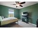 This cozy bedroom features green walls, carpet floors, and a ceiling fan for added comfort at 605 Black Eagle Dr, Groveland, FL 34736