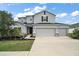 Charming two-story home with a three car garage, manicured landscaping, and a welcoming front entrance at 605 Black Eagle Dr, Groveland, FL 34736