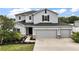 Charming two-story home featuring a three car garage, neutral color scheme, and manicured landscaping at 605 Black Eagle Dr, Groveland, FL 34736