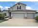 Charming two-story home featuring a three car garage, neutral color scheme, and manicured landscaping at 605 Black Eagle Dr, Groveland, FL 34736