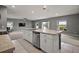 Bright kitchen featuring white cabinets, a stainless steel dishwasher, and a view of the living area at 605 Black Eagle Dr, Groveland, FL 34736