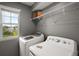 Bright laundry room featuring a large window and modern washer and dryer for convenience at 605 Black Eagle Dr, Groveland, FL 34736