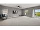 Spacious living room featuring neutral tones, a ceiling fan, and sliding glass doors to an outdoor patio at 605 Black Eagle Dr, Groveland, FL 34736