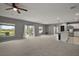 Spacious living room flowing into kitchen, with large windows for ample natural light and sliding glass door at 605 Black Eagle Dr, Groveland, FL 34736