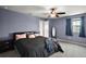 A spacious main bedroom with a large bed, dark furniture, ceiling fan, and a window at 605 Black Eagle Dr, Groveland, FL 34736