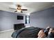 A spacious main bedroom with a large bed, dark furniture, ceiling fan, and a window at 605 Black Eagle Dr, Groveland, FL 34736