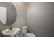 Elegant powder room with modern fixtures, decorative mirror, and chic brick-patterned accent wall at 605 Black Eagle Dr, Groveland, FL 34736