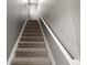 Carpeted staircase with white railings and baseboards, offering a clean and modern aesthetic at 605 Black Eagle Dr, Groveland, FL 34736