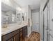 Bathroom with double sinks, modern vanity, large mirror, shower with glass doors, and modern fixtures at 6301 Whittle Ct, The Villages, FL 32163