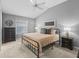 A bedroom with a neutral palette, fan, window, and dark wood furnishings for a warm and inviting ambiance at 6301 Whittle Ct, The Villages, FL 32163