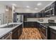 Modern kitchen with sleek black cabinetry, stainless steel appliances, and a breakfast bar at 6301 Whittle Ct, The Villages, FL 32163