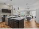 Open-concept kitchen and living room area with stainless steel appliances, pendant lighting, and modern furniture at 6301 Whittle Ct, The Villages, FL 32163