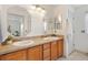 Bathroom with double sinks, wood cabinets, and elegant mirrors for a luxurious feel at 654 Fayette Ct, The Villages, FL 32162