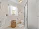 Bright bathroom with white walls, a window, a toilet, and a glass-enclosed shower at 654 Fayette Ct, The Villages, FL 32162