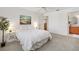 Calming bedroom featuring soft carpet, neutral tones, and an adjacent bathroom for convenience at 654 Fayette Ct, The Villages, FL 32162