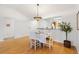 Bright dining area featuring hardwood floors, white furniture, and a decorative chandelier above at 654 Fayette Ct, The Villages, FL 32162