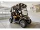Garage features a modern golf cart parked on a neutral rug at 654 Fayette Ct, The Villages, FL 32162
