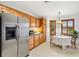 Bright eat-in kitchen featuring wood cabinetry and stainless steel appliances at 654 Fayette Ct, The Villages, FL 32162