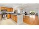 A bright open floor plan with stainless steel appliances, wood cabinets, and tile floors at 654 Fayette Ct, The Villages, FL 32162