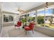 Bright sunroom features a ceiling fan, tiled floors, and serene views of the backyard at 654 Fayette Ct, The Villages, FL 32162