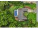 Aerial view of a home with a screened pool, set amidst lush greenery and well-maintained landscaping at 717 Southeast 46Th Ct, Ocala, FL 34471